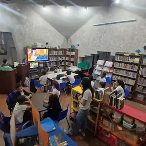 Crianças assistem a vídeo educativo durante aula na biblioteca comunitária de Copacabana, Rio de Janeiro.